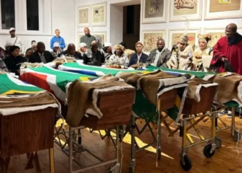 Coffins draped in South African flags at Khoi and San reburial ceremony in Steinkopf, attended by community leaders and officials