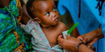 Infant undergoing malnutrition screening by community health worker in South Africa