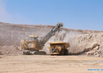 Large-scale mining operation in Namibia with heavy machinery loading ore at an open-pit site