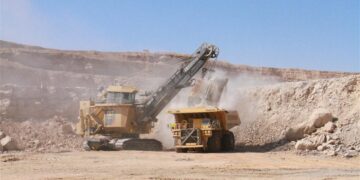 Large-scale mining operation in Namibia with heavy machinery loading ore at an open-pit site