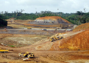 Ghana open-pit gold mine with heavy trucks and excavators as government introduces new sliding-scale gold royalty regime.