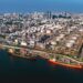 Aerial view of oil refinery and storage tanks with tankers docked at an African coastal energy terminal