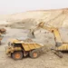 Open-pit mining trucks and excavator operating at a gold mine in Senegal amid government review of mining licences.