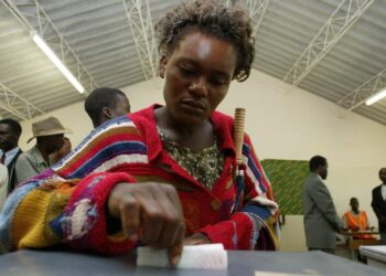 Woman voting at polling station in Zambia during elections, highlighting women’s political participation amid abuse allegations