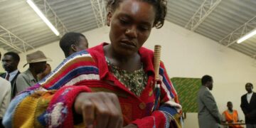 Woman voting at polling station in Zambia during elections, highlighting women’s political participation amid abuse allegations