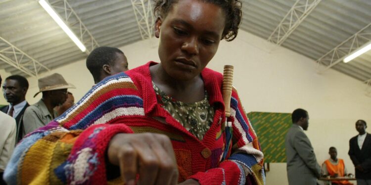Woman voting at polling station in Zambia during elections, highlighting women’s political participation amid abuse allegations