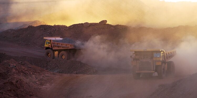 Heavy-duty trucks operate in an open-pit gold mine in Africa as governments tighten control over mining licences