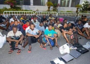 Rescued trafficking victims, including children, sit under supervision during a Ghana anti-trafficking operation in Accra