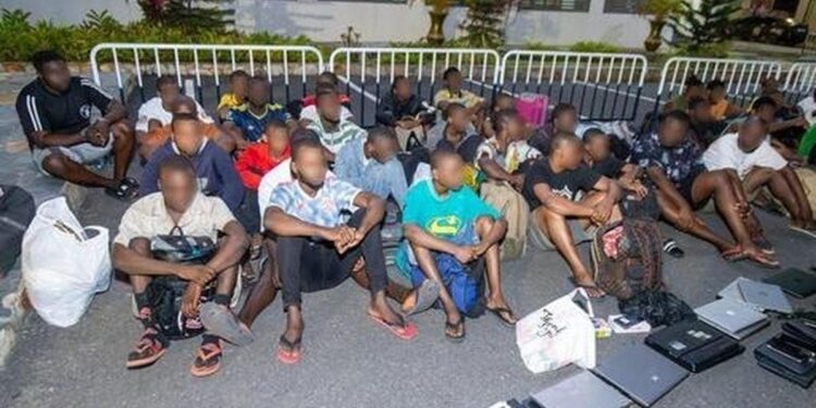 Rescued trafficking victims, including children, sit under supervision during a Ghana anti-trafficking operation in Accra