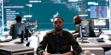 African military cyber operations centre with officer monitoring digital security systems on multiple screens