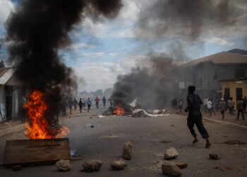 Protesters run past burning barricades during unrest following Tanzania’s disputed 2025 election