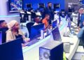 Broadcast newsroom in Nigeria with journalists and producers working at computer stations during live programming