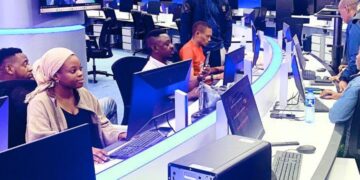 Broadcast newsroom in Nigeria with journalists and producers working at computer stations during live programming