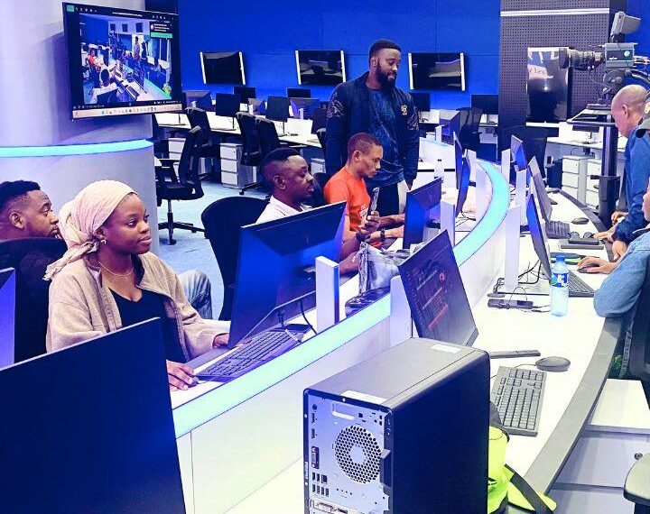 Broadcast newsroom in Nigeria with journalists and producers working at computer stations during live programming