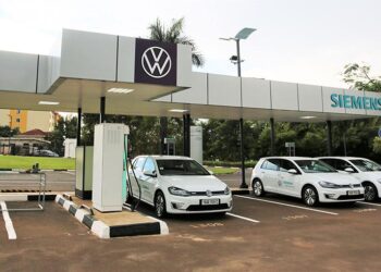 Electric vehicles charging at a public EV station in Kigali, Rwanda, featuring Volkswagen cars under a Siemens-branded charging canopy