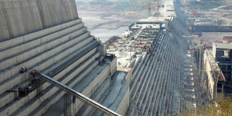 Grand Ethiopian Renaissance Dam under construction showing massive concrete walls, spillway structure, and power generation facilities along the Blue Nile in Ethiopia.
