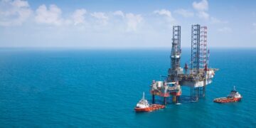An offshore drilling platform operates in Angola’s deepwater oil sector alongside support vessels in the Atlantic Ocean
