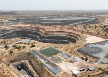 Aerial view of a large open-pit gold mine in Burkina Faso with excavation pits, processing areas and dry Sahel landscape surrounding the mining site