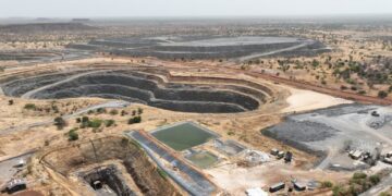 Aerial view of a large open-pit gold mine in Burkina Faso with excavation pits, processing areas and dry Sahel landscape surrounding the mining site