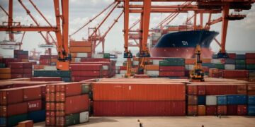Large container port with stacked shipping containers and cranes loading cargo onto a vessel, illustrating global trade flows between Africa and China