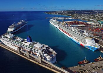 Aerial view of multiple cruise ships docked at Bridgetown Port in Barbados alongside the Caribbean coastline and port infrastructure