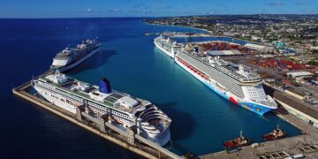Aerial view of multiple cruise ships docked at Bridgetown Port in Barbados alongside the Caribbean coastline and port infrastructure