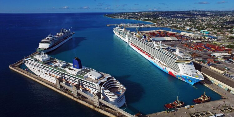 Aerial view of multiple cruise ships docked at Bridgetown Port in Barbados alongside the Caribbean coastline and port infrastructure