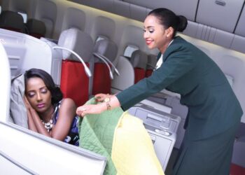 Ethiopian Airlines cabin crew assisting a passenger in business class during flight