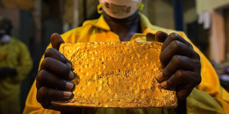 Worker holding a gold dore bar inside a Ghanaian gold processing facility