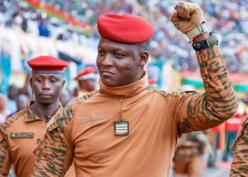 Burkina Faso military leader Captain Ibrahim Traore raises his fist during a public appearance surrounded by soldiers wearing red berets