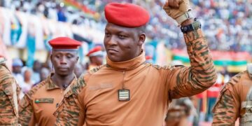 Burkina Faso military leader Captain Ibrahim Traore raises his fist during a public appearance surrounded by soldiers wearing red berets