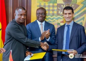 Ghana Energy Minister John Jinapor shakes hands with an Eni official as Finance Minister Cassiel Ato Forson applauds during the signing of the OCTP gas expansion agreement in Accra.