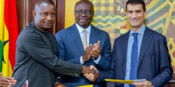 Ghana Energy Minister John Jinapor shakes hands with an Eni official as Finance Minister Cassiel Ato Forson applauds during the signing of the OCTP gas expansion agreement in Accra.