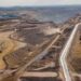 Aerial view of a large open-pit copper mining site in Namibia with haul roads, excavation areas and heavy industrial earthworks stretching across a dry landscape