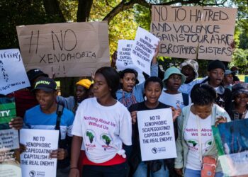 A group of anti-xenophobia protesters in South Africa hold placards condemning hate, violence and scapegoating of migrants during a public demonstration.
