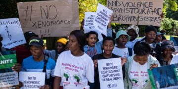 A group of anti-xenophobia protesters in South Africa hold placards condemning hate, violence and scapegoating of migrants during a public demonstration.