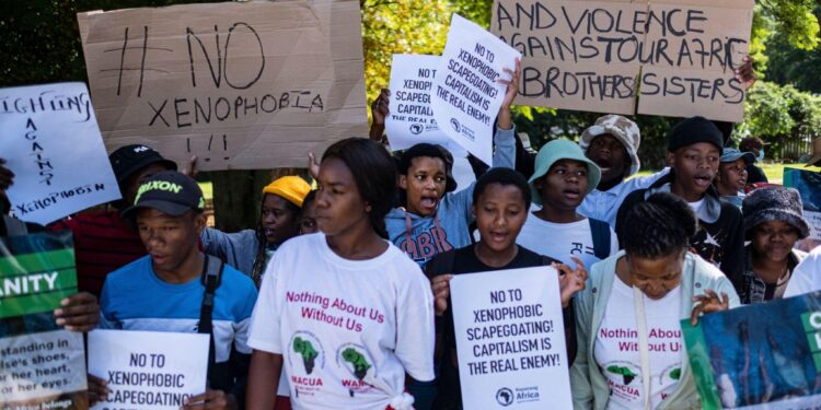 A group of anti-xenophobia protesters in South Africa hold placards condemning hate, violence and scapegoating of migrants during a public demonstration.