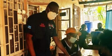 Healthcare workers assist patients inside a clinic in Zambia, highlighting frontline delivery of HIV and primary care services