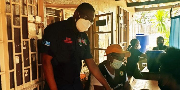 Healthcare workers assist patients inside a clinic in Zambia, highlighting frontline delivery of HIV and primary care services