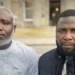 Kow Mensah (left) and Joshua Amissah (right), two Ghanaian fishermen, pose outside a court building after proceedings related to their long-running case over alleged mistreatment aboard a Scottish fishing trawler