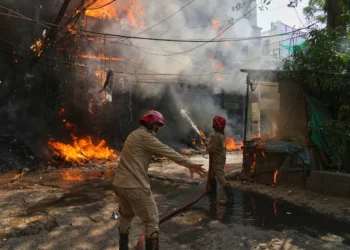 Firefighters battle a large blaze in a densely populated neighbourhood in New Delhi as flames and thick smoke engulf buildings amid a network of overhead electrical cables