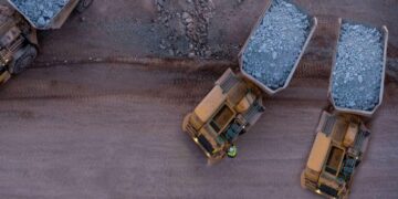 Aerial view of heavy haul trucks transporting mineral ore at a large-scale African mining operation, highlighting the continent's growing role in global critical mineral supply chains