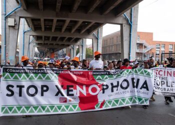 Demonstrators march through a South African city carrying a large banner reading 'Stop Xenophobia' during a public protest against discrimination and violence targeting migrants and foreign nationals