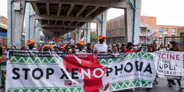 Demonstrators march through a South African city carrying a large banner reading 'Stop Xenophobia' during a public protest against discrimination and violence targeting migrants and foreign nationals
