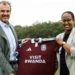 Aston Villa and Visit Rwanda representatives hold a claret football shirt displaying the Visit Rwanda front-of-shirt logo