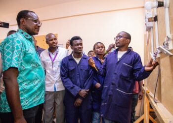 TVET trainees in blue workshop coats demonstrate technical equipment at Kenya Coast National Polytechnic in Mombasa