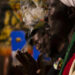A Rastafarian man wearing red, gold and green clothing exhales cannabis smoke during a religious gathering