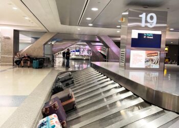Airport baggage carousel carrying passengers' luggage inside a modern international airport terminal