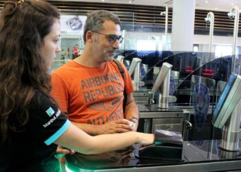 Traveller receiving assistance while scanning a passport at an automated control gate at Istanbul Airport in Turkey