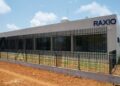 Exterior of a Raxio data centre building with secure perimeter fencing and the company’s logo displayed on the façade